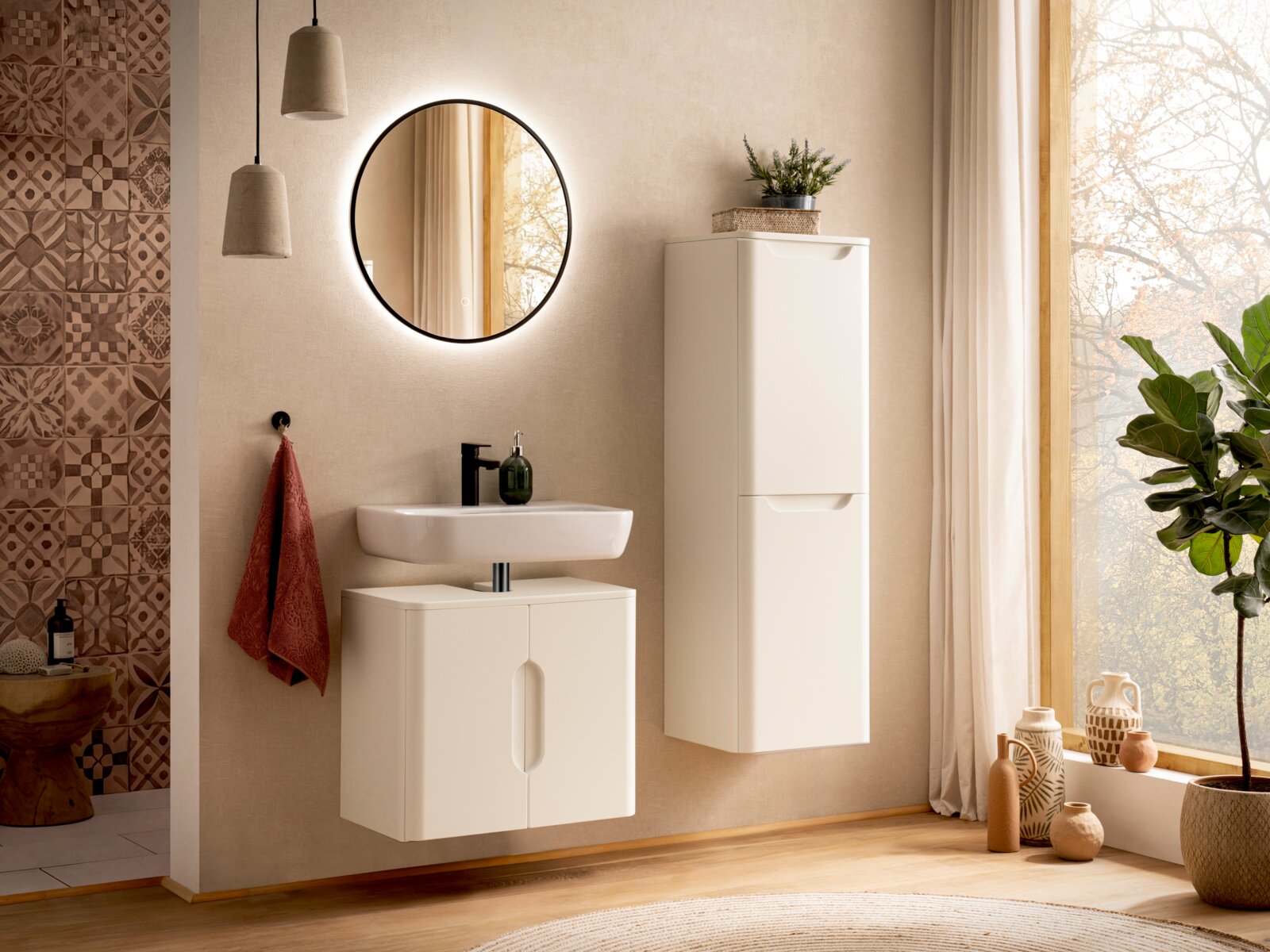 Modernes Badezimmer-Set mit weißem, wandhängendem Waschtischunterschrank und hohem Hochschrank, rundem Spiegel mit LED-Hinterleuchtung und schwarzer Armatur; Frontansicht in leicht schräger Perspektive.