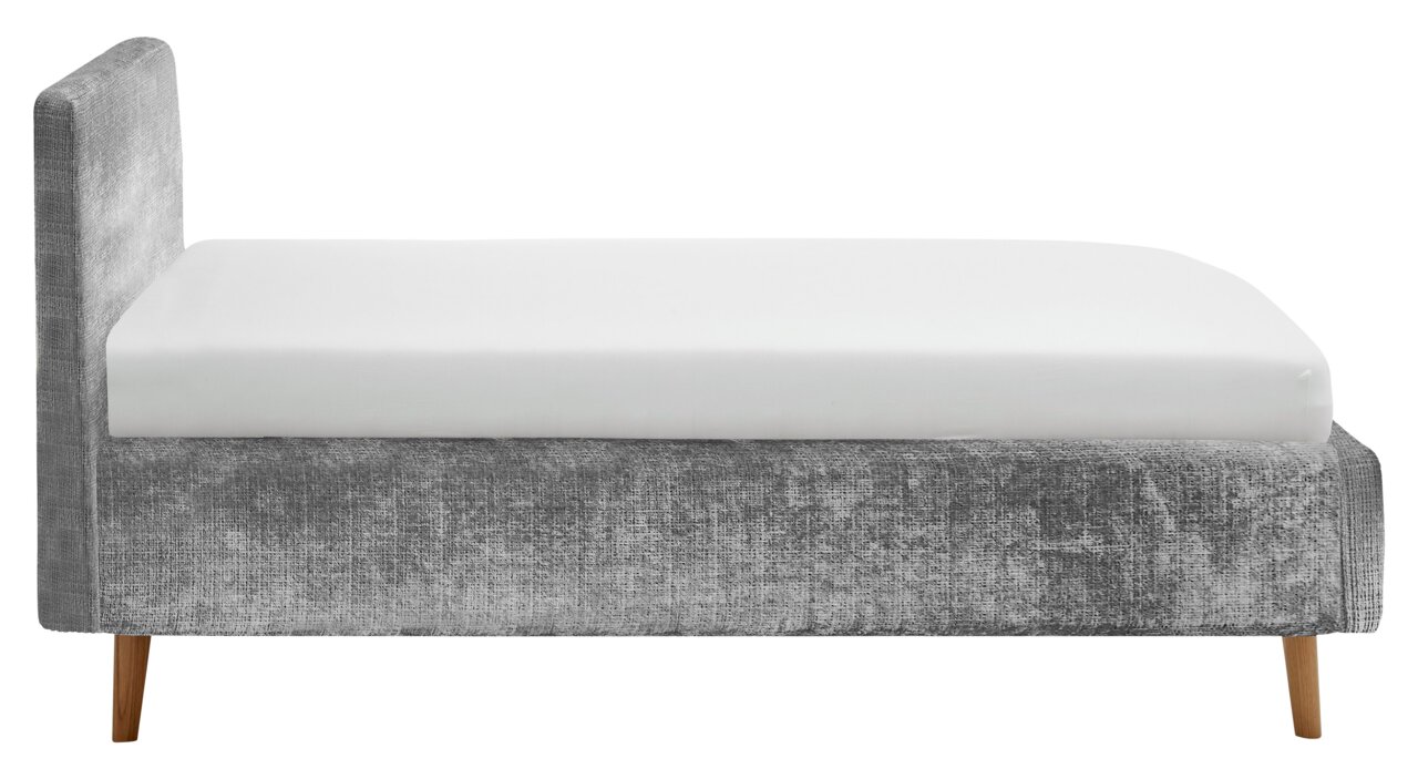 Zijaanzicht van een grijs gestoffeerd bedframe met houten poten en een wit matras.