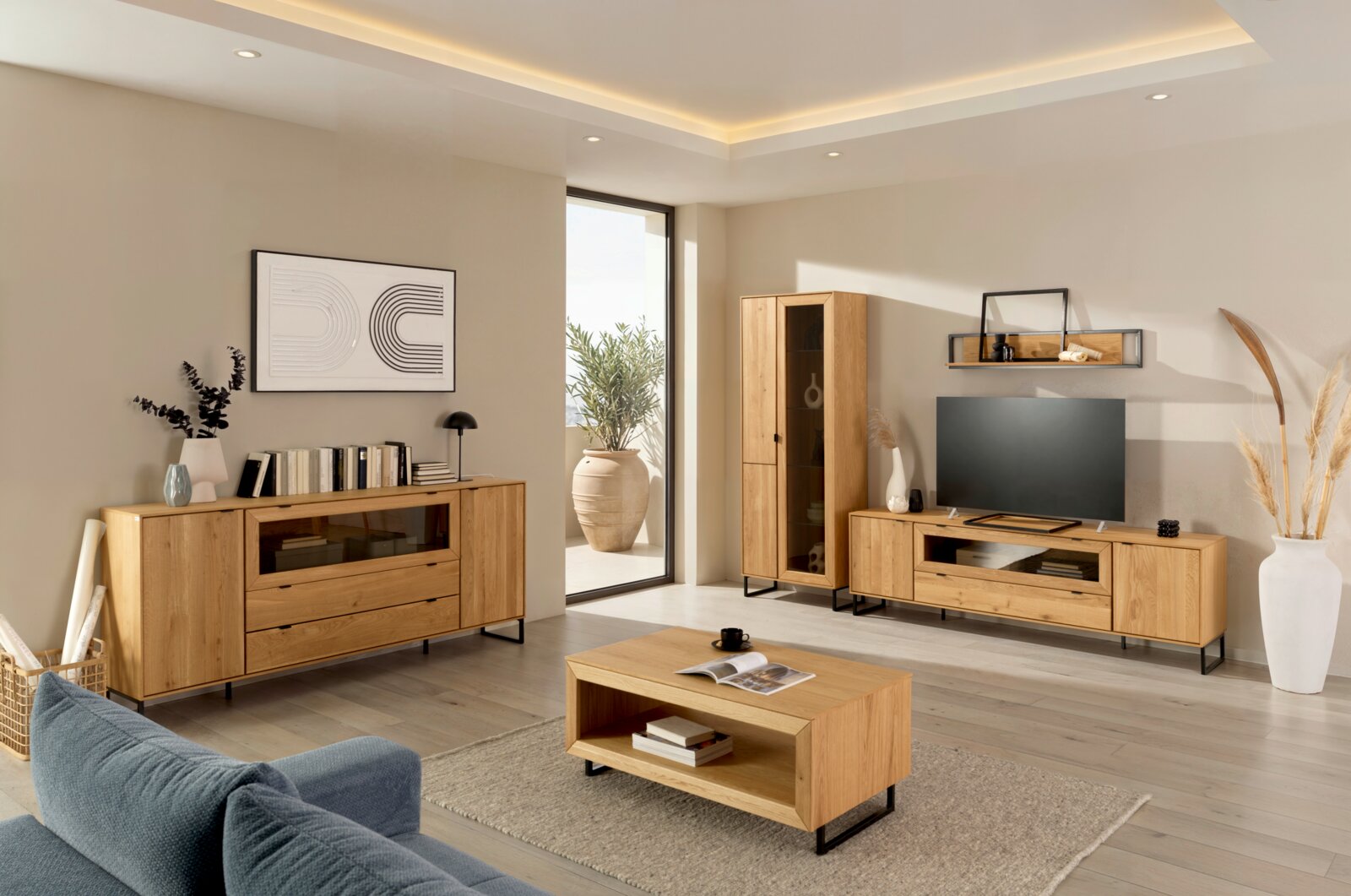 Z2 Highboard EDGE Modernes Wohnzimmer mit Möbelset aus hellem Holz: TV-Lowboard, Sideboard, Vitrine und Couchtisch auf schwarzen Metallfüßen, frontal in leichter Weitwinkel-Perspektive aufgenommen.
