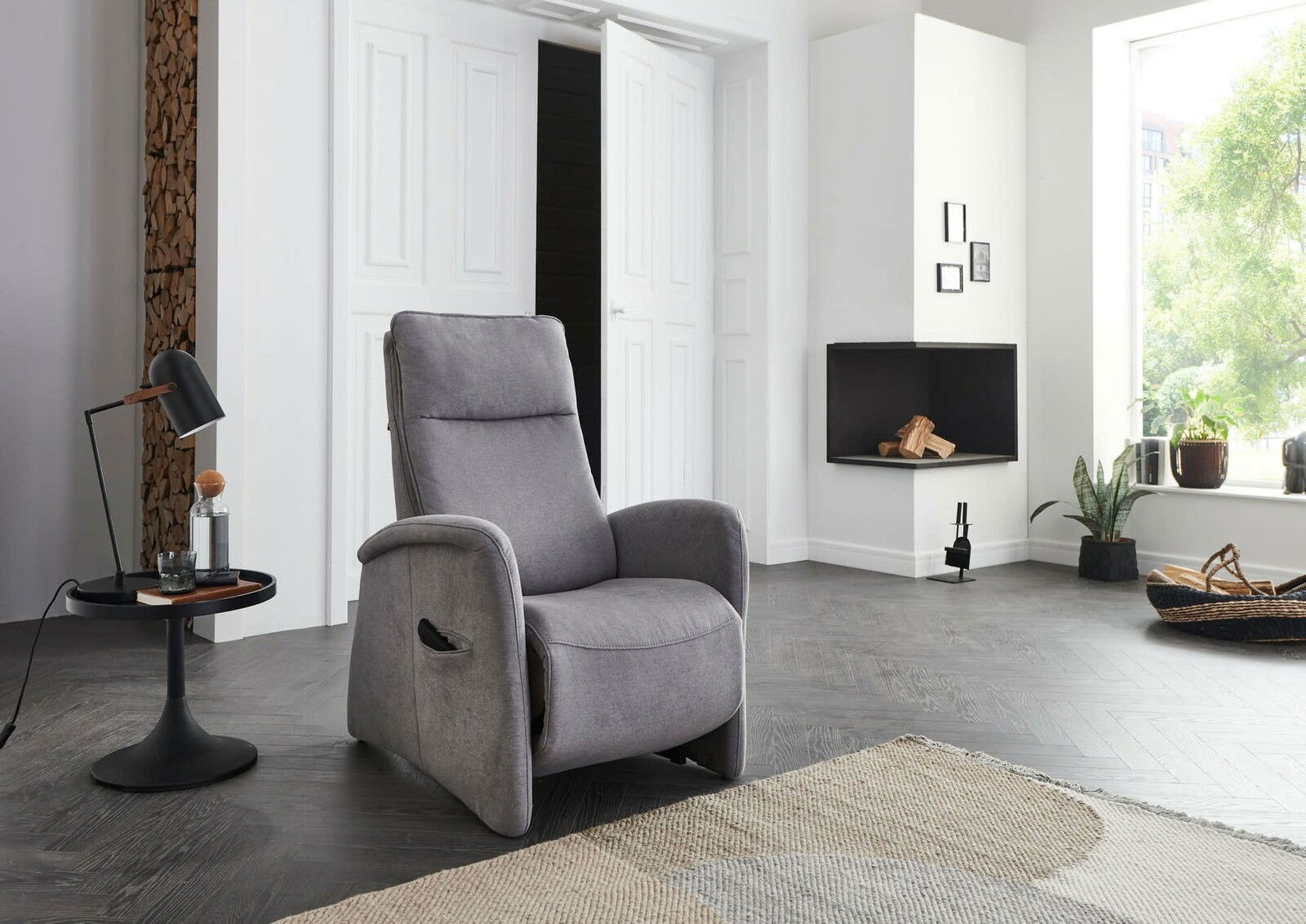 Grauer Relaxsessel in modernem Wohnzimmer, seitliche Perspektive