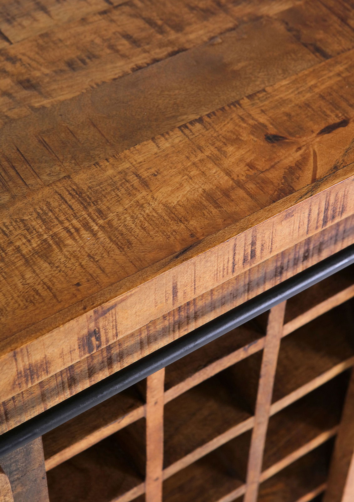 Nahaufnahme eines rustikalen Barschrankes aus Holz mit Gitterfächern, von oben betrachtet.