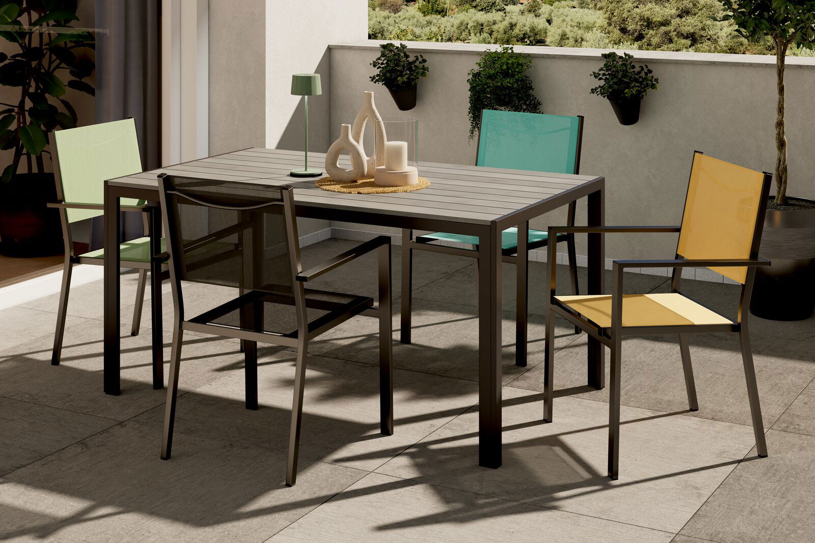 Moderner Balkon mit einem Tisch und vier bunten Stapelsesseln in der Sonne, Perspektive von schräg oben.