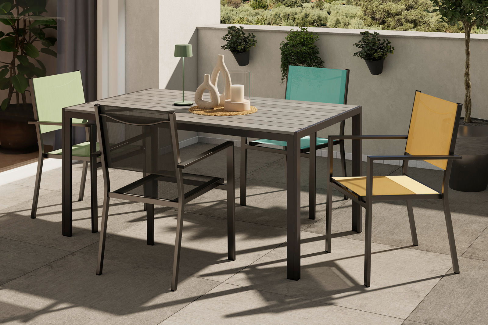 Moderner Balkon mit einem Tisch und vier bunten Stapelsesseln in der Sonne, Perspektive von schräg oben.