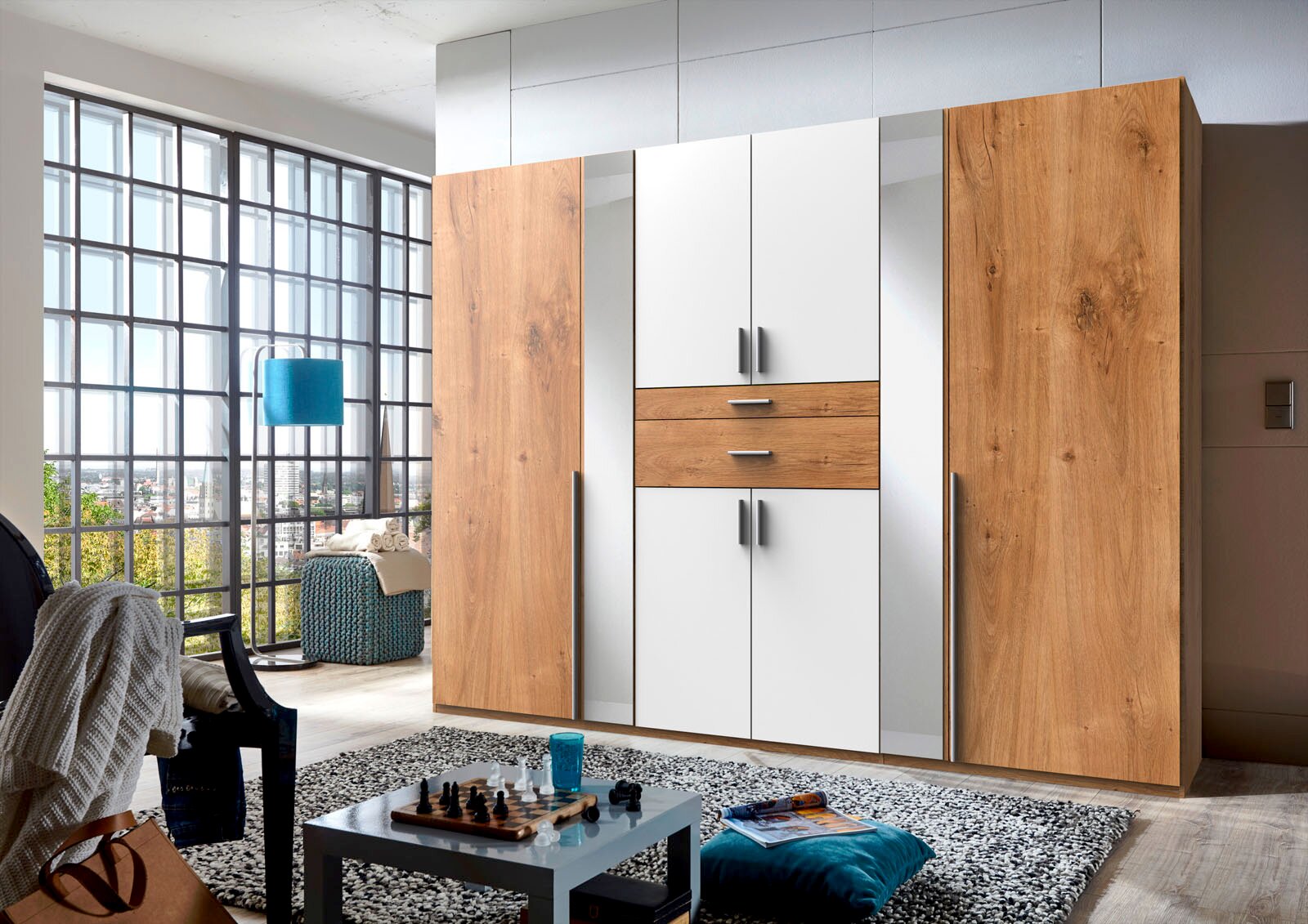 Moderner 8-türiger Drehtürenschrank in Holzoptik und Weiß, frontal abgebildet in einem stilvollen Wohnzimmer mit großen Fenstern.