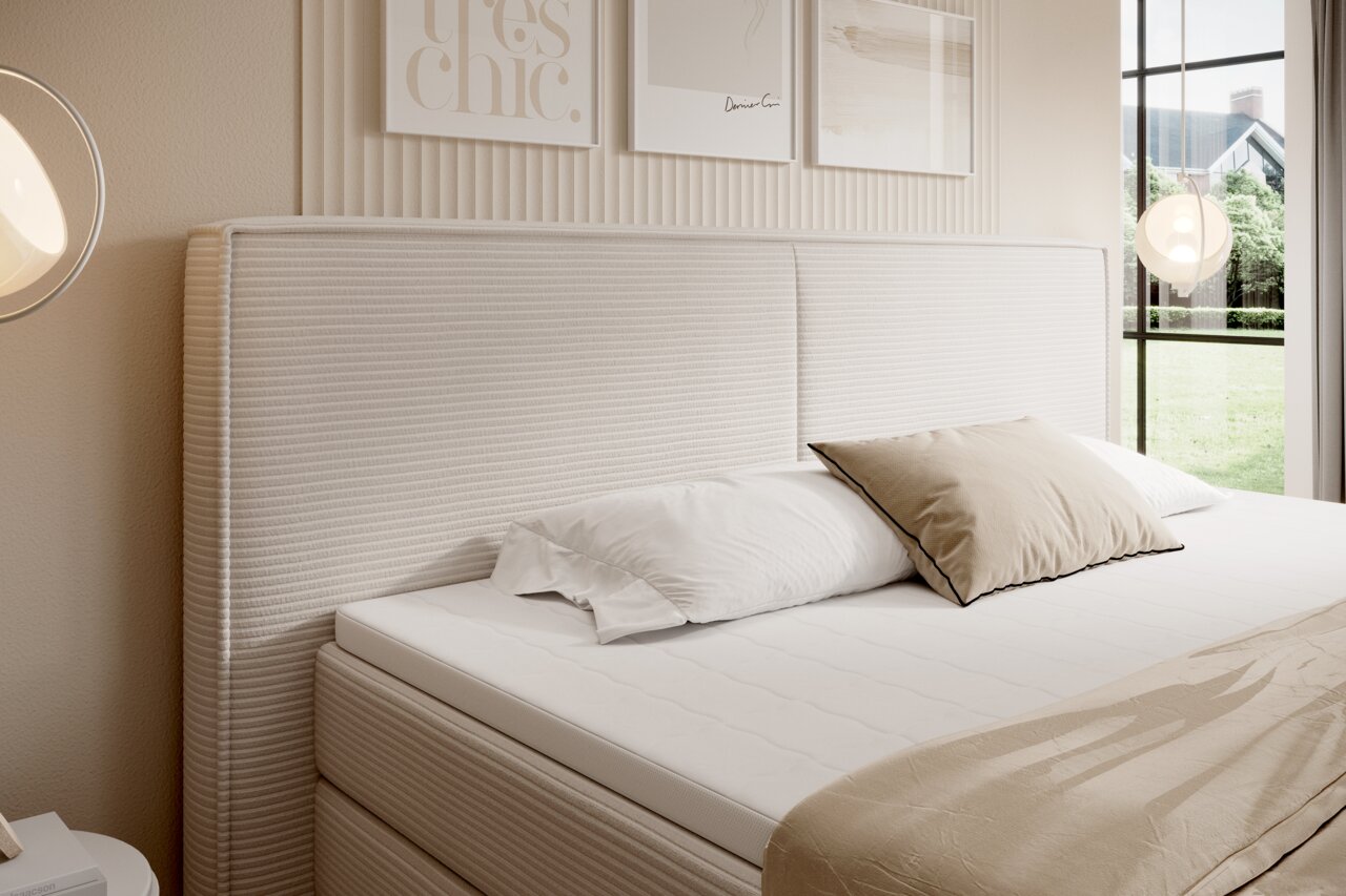 Boxspringbett mit gestepptem Kopfteil in einem modernen Schlafzimmer, seitliche Perspektive