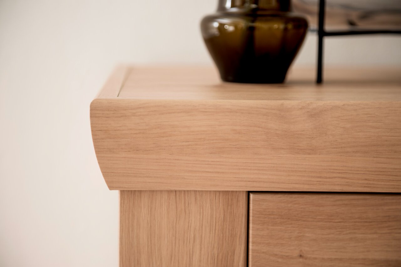 Nahaufnahme einer Holzmöbelecke mit dekorativer Vase, seitliche Perspektive
