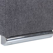 Nahaufnahme einer grauen, texturierten Stoffoberfläche mit einem glänzenden, metallischen Sockel.