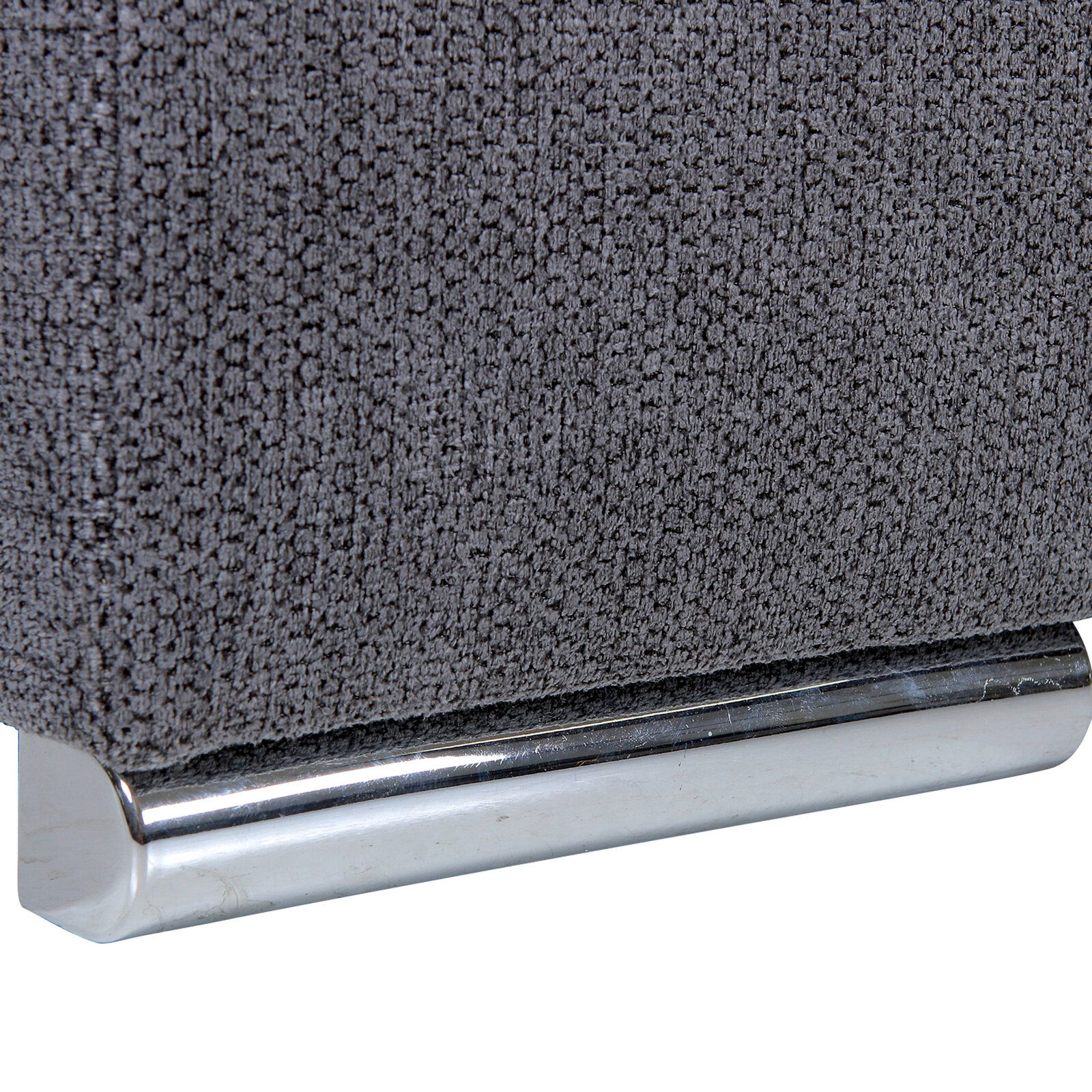 Nahaufnahme einer grauen, texturierten Stoffoberfläche mit einem glänzenden, metallischen Sockel.