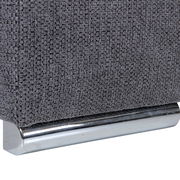 Nahaufnahme einer grauen, texturierten Stoffoberfläche mit einem glänzenden, metallischen Sockel.