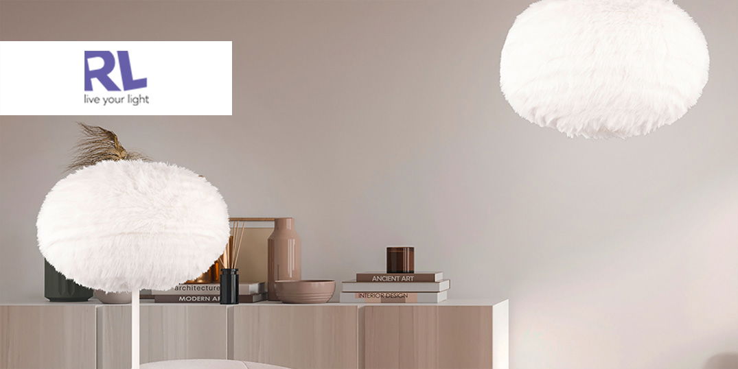 Zwei flauschige, weiße Lampen leuchten in einem modern eingerichteten Raum mit Deko und Büchern.