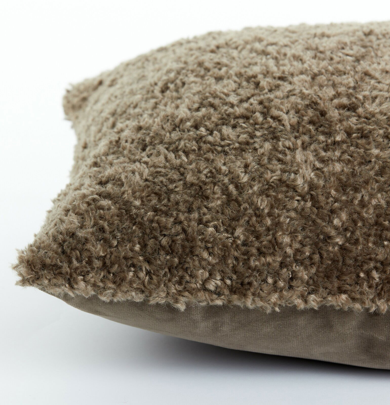 Nahaufnahme eines braunen Kissens mit flauschiger Textur, seitliche Perspektive