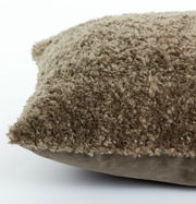 Nahaufnahme eines braunen Kissens mit flauschiger Textur, seitliche Perspektive