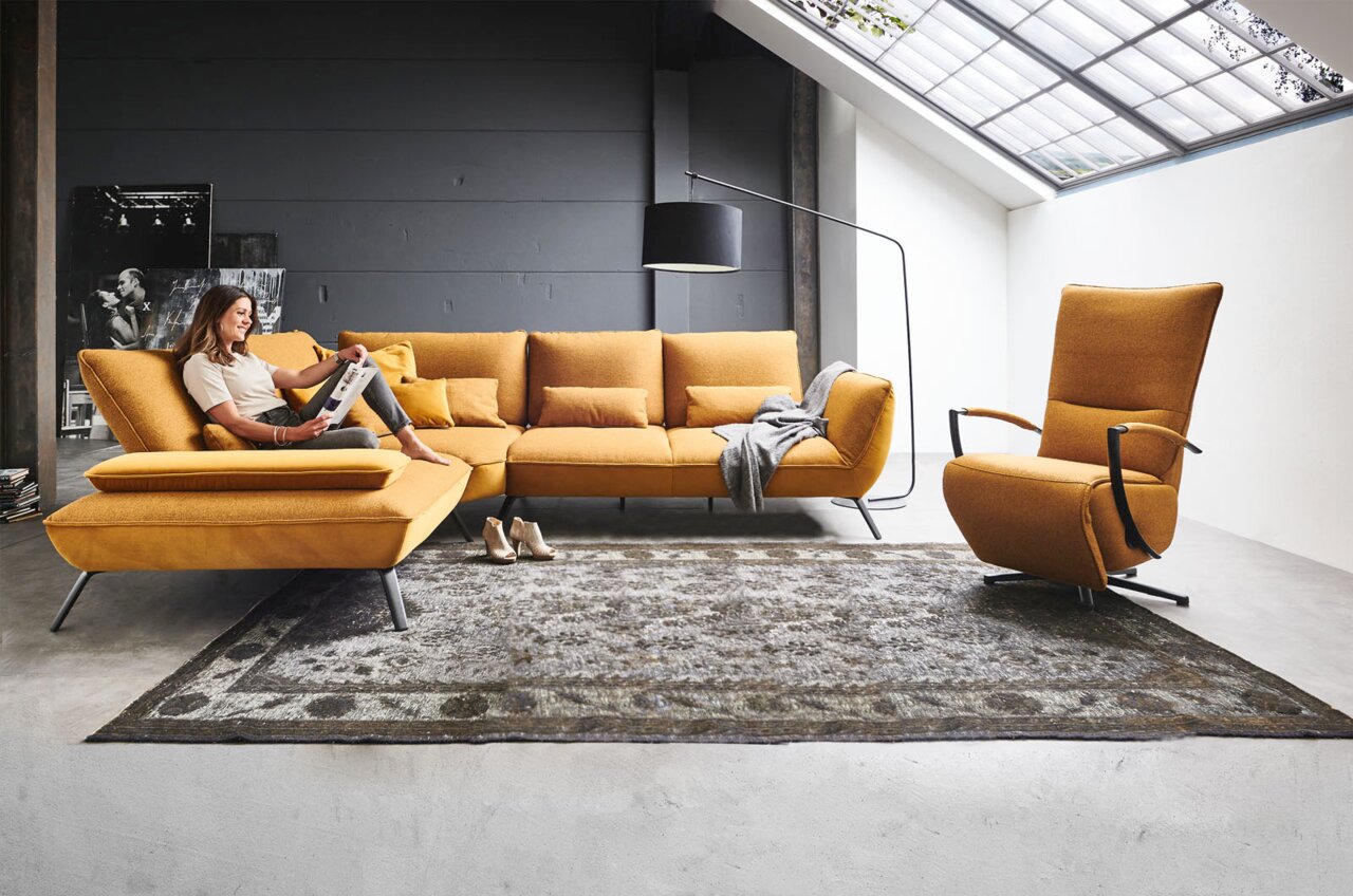 Moderano Relaxsessel ALPHA Moderne Wohnzimmereinrichtung mit einer senfgelben Eckgarnitur und einem passenden drehbaren Relaxsessel, seitliche Perspektive.