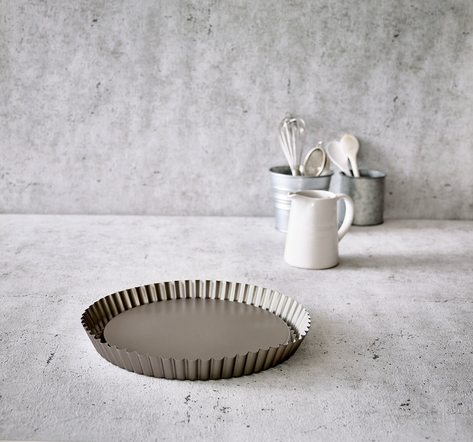 Birkmann Vorm voor fruittaart BASIC BAKING Obstbodenform Ø 30 cm aus Metall, seitliche Perspektive auf einer Küchenarbeitsplatte, im Hintergrund Küchengeräte.