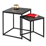 Zwei moderne Beistelltische aus schwarzem Metall mit quadratischen Platten, einer mit einer goldenen Schale und der andere mit einem roten Buch, seitliche Perspektive.