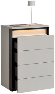 Hochkommode mit vier Schubladen, teilweise geöffnet, mit integrierter Beleuchtung und einer Tischlampe auf der Oberseite, seitliche Perspektive