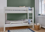 Stapelbed met wit frame en valbeveiliging, ladder aan de zijkant, vooraanzicht, kinderkamer met groene achtergrond.