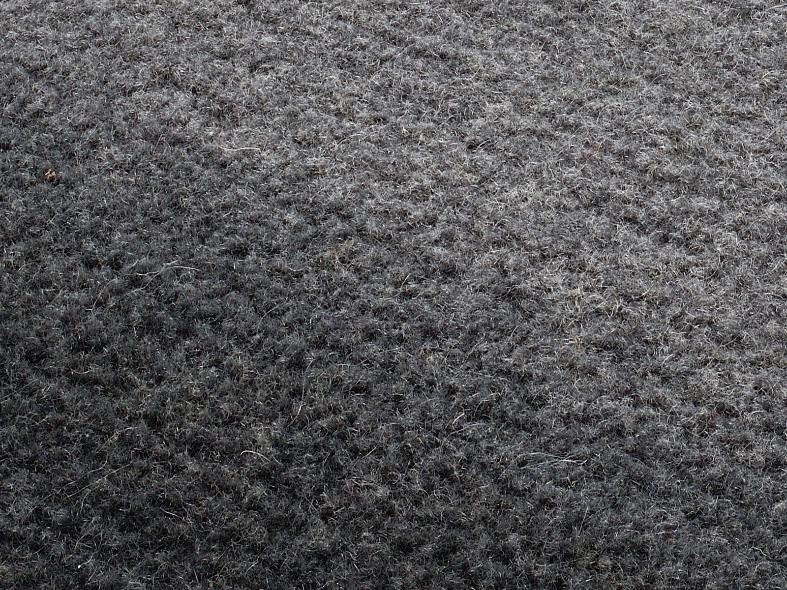 Nahaufnahme eines grauen Wollteppichs mit texturierter Oberfläche