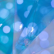 Abstrakte Nahaufnahme aus leicht schräger Draufsicht: transparente, blau schimmernde Kunststofffolien mit weichen, runden Lichtreflexen und feinen Linien.