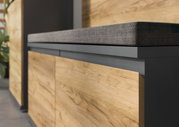Nahaufnahme einer modernen Schuhbank mit Holzverkleidung und gepolstertem Sitzkissen, seitliche Perspektive.