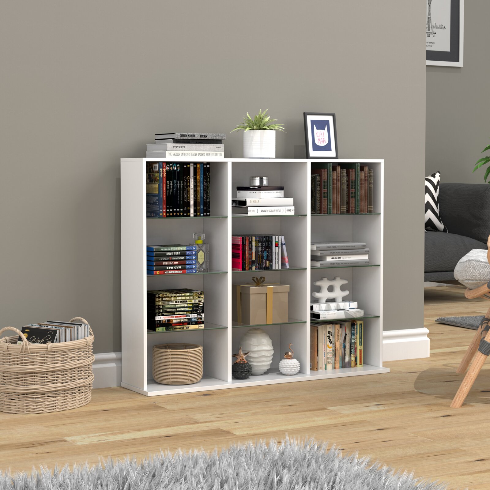 Weißes, modernes Regal mit neun Fächern und Glasböden, dekoriert mit Büchern, Pflanzen und Dekoartikeln, in einem Wohnzimmer – Frontansicht leicht schräg von links.