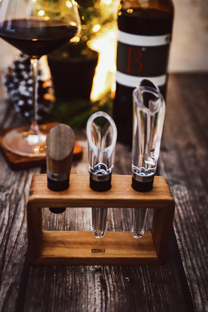 Wein-Genießer-Set Vine, 3-tlg., bestehend aus einem Weinbelüfter, einem Ausgießer und einem Verschluss, präsentiert auf einem Holzständer. Perspektive von vorne.