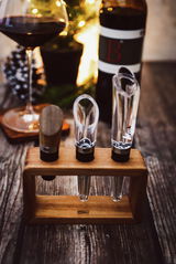 Wein-Genießer-Set Vine, 3-tlg., bestehend aus einem Weinbelüfter, einem Ausgießer und einem Verschluss, präsentiert auf einem Holzständer. Perspektive von vorne.