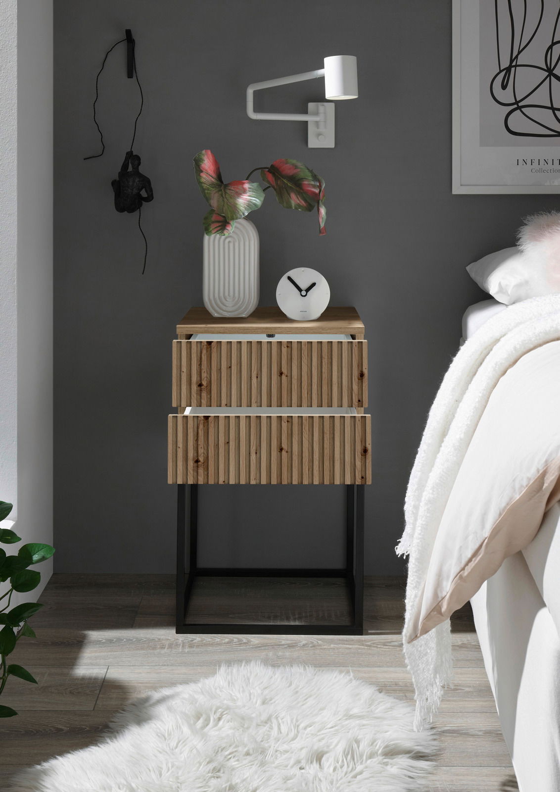 Moderne Nachtkommode aus Holz mit zwei Schubladen, dekoriert mit einer Vase und einer Uhr, seitliche Perspektive