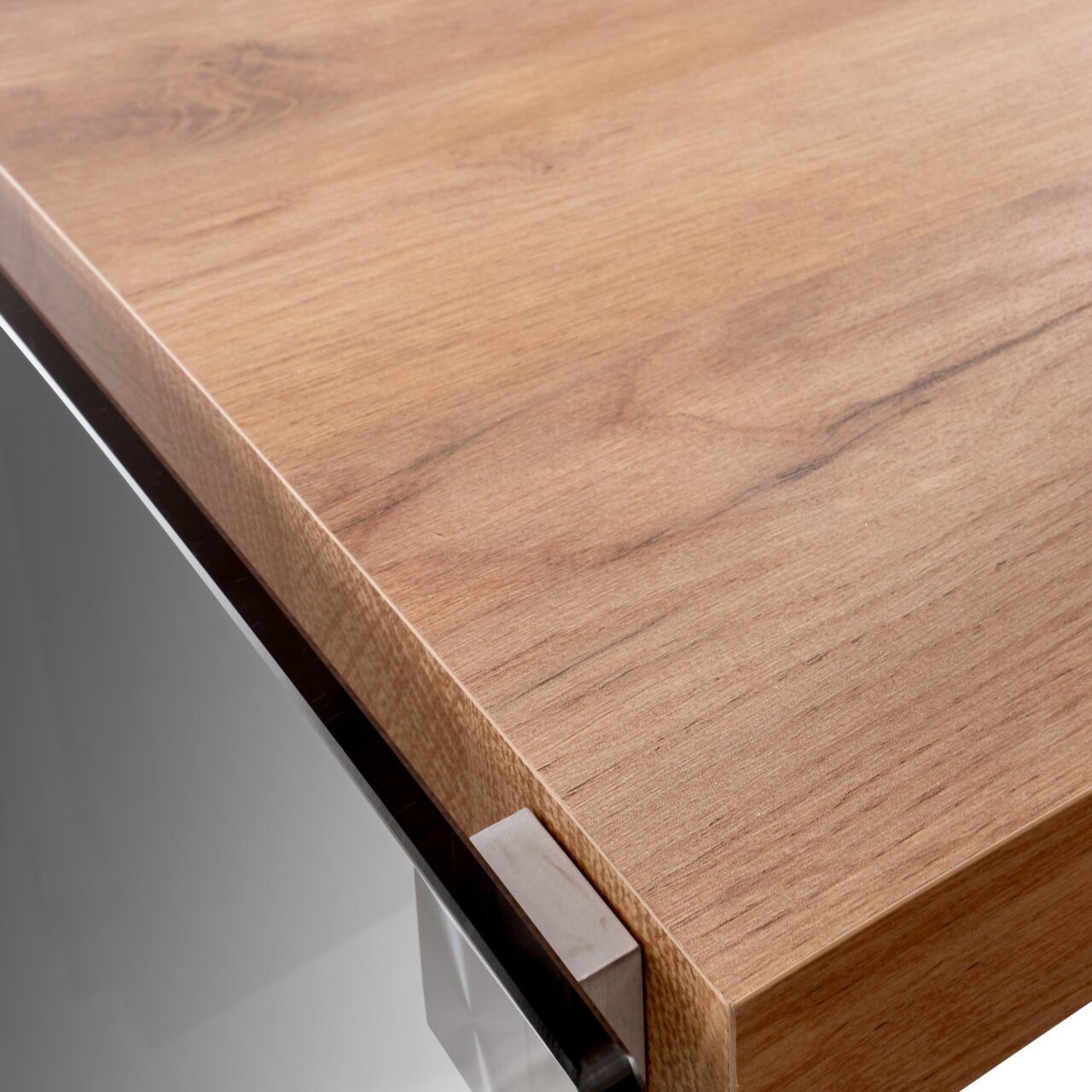 Nahaufnahme einer Ecke eines Eck-Schreibtisches mit Holzoberfläche und Metallverbindung, aus der Perspektive von oben.