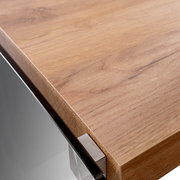 Nahaufnahme einer Ecke eines Eck-Schreibtisches mit Holzoberfläche und Metallverbindung, aus der Perspektive von oben.