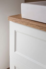 Nahaufnahme eines Waschtisch-Sets mit weißem Waschbecken und Holzarbeitsplatte, seitliche Perspektive