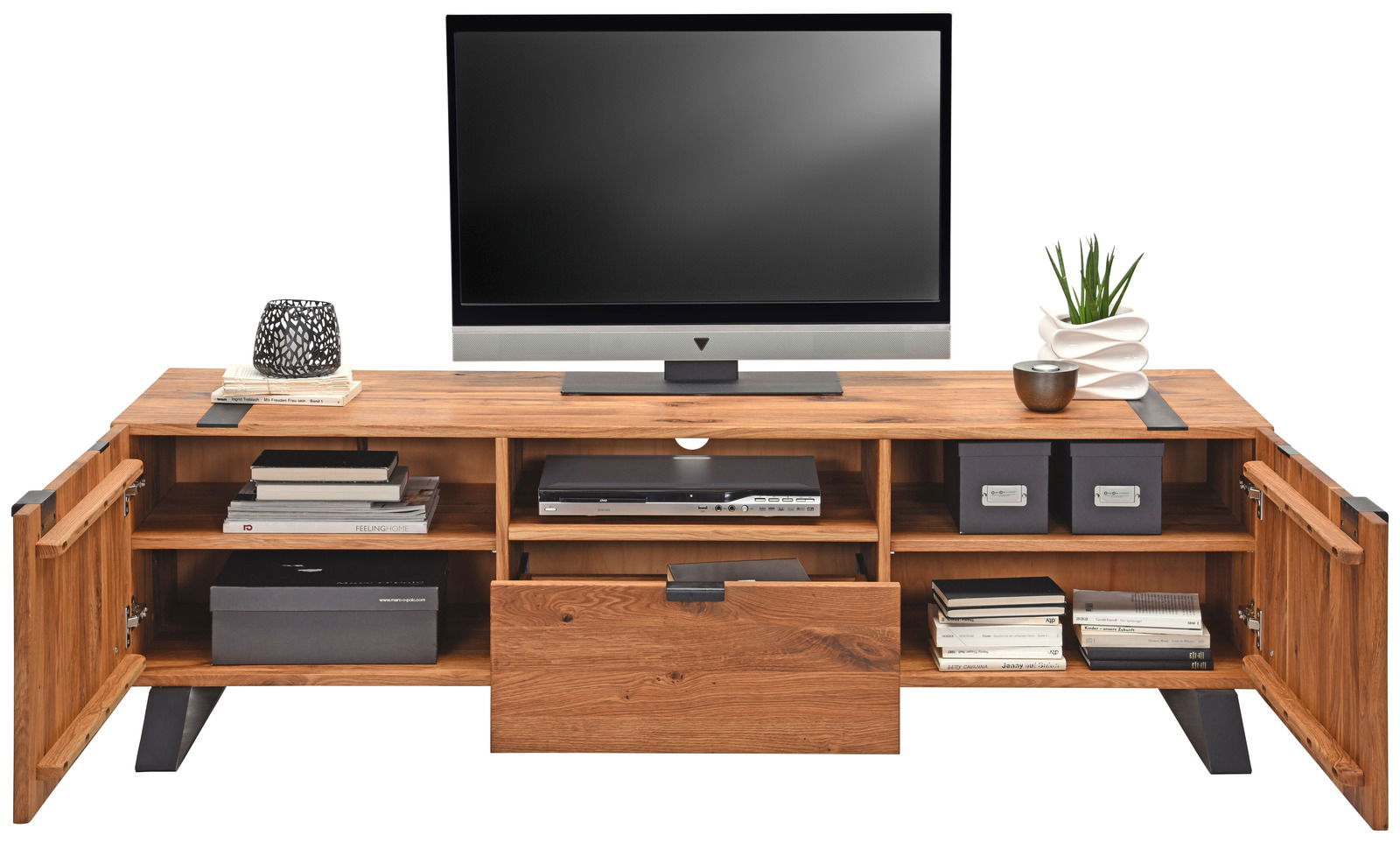 TV-Lowboard aus Holz mit offenen Fächern und Schubladen, frontal fotografiert, dekoriert mit Büchern, Pflanzen und Kerzenhalter.