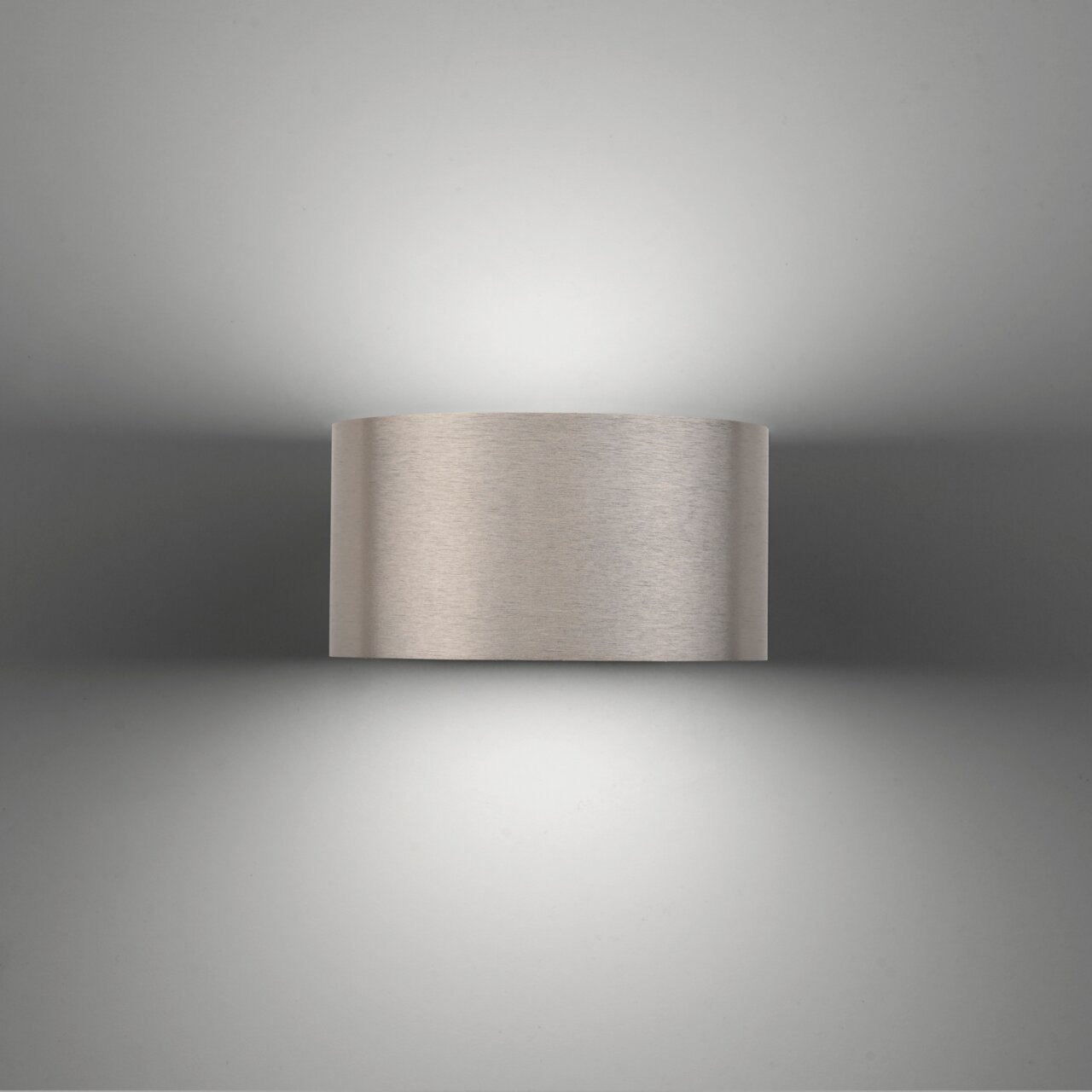 Moderne Wandleuchte PURE Clipse in gebürstetem Metall, frontal betrachtet, mit sanfter Lichtverteilung nach oben und unten.