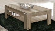Moderner Couchtisch aus Holz mit rechteckiger Form, abgebildet in einer schrägen Perspektive von vorne, mit einer dekorativen Schale und Büchern auf einem schwarzen Teppich.
