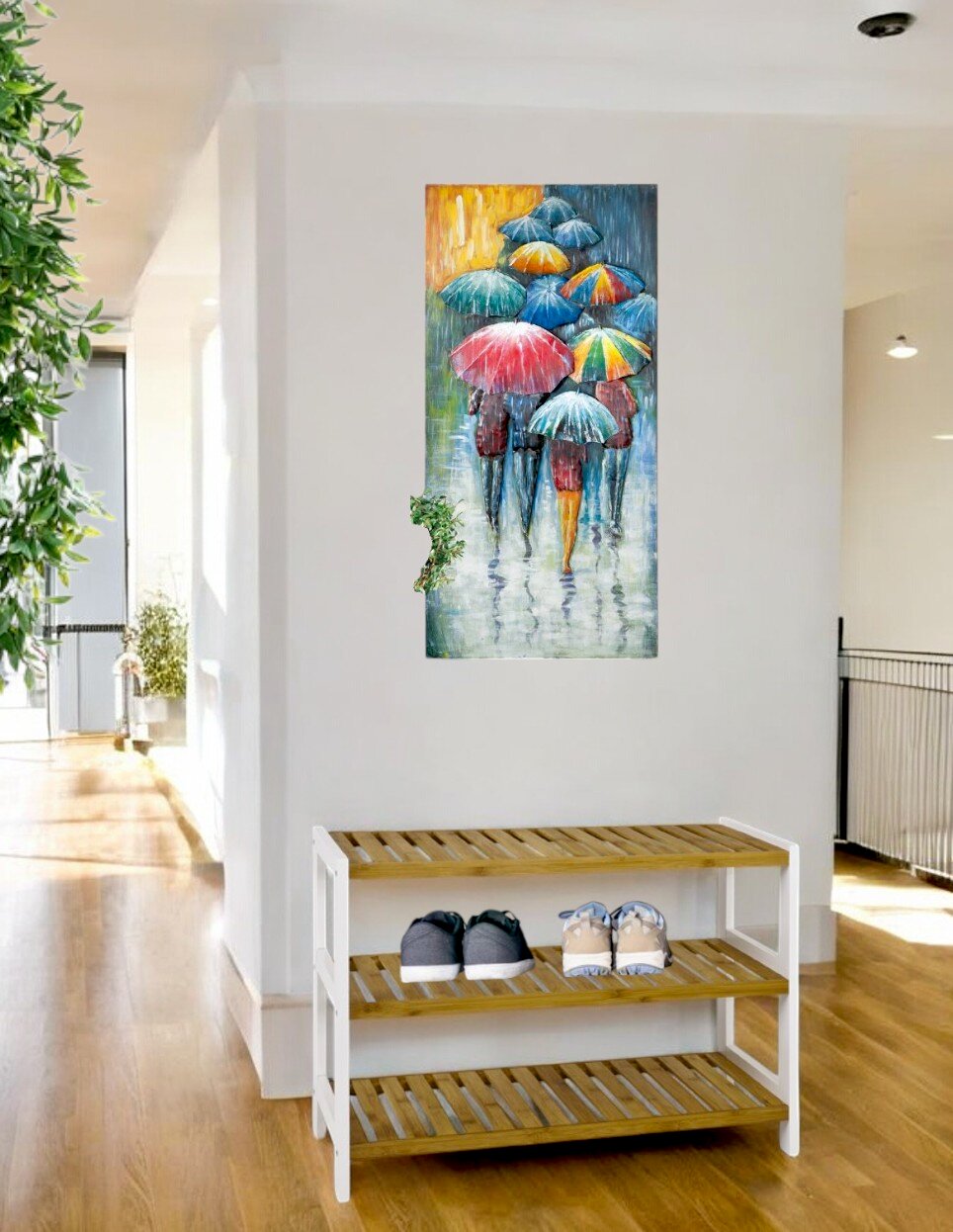 Modernes Wandbild/Leinwand im Hochformat mit bunten Regenschirmen und Personen im Regen, frontal aus Augenhöhe an einer weißen Flurwand über einer Holz-Schuhbank aufgenommen.