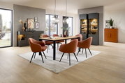 Eetkamer met een moderne eettafel en zes stoelen in een lichte ruimte, gezien van voren
