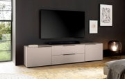Modernes, niedriges TV-Lowboard/Sideboard in Hellgrau mit schwarzen Griffleisten unter einem wandmontierten Flachbild-TV im Wohnzimmer, frontale Perspektive mit leichter Seitenansicht.
