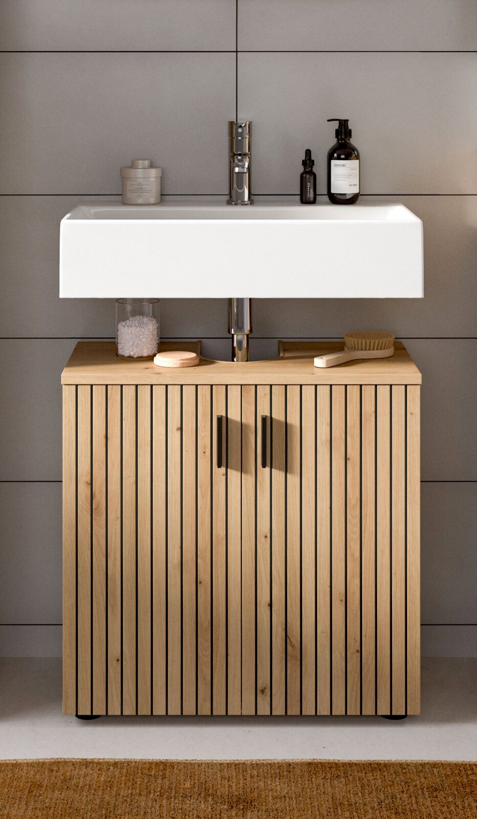 Modernes Badezimmer-Waschbecken mit weißem rechteckigem Aufsatzbecken, verchromter Armatur und Unterschrank aus hellem Holz mit vertikalen Lamellen und schwarzen Griffen; Frontansicht auf Augenhöhe.
