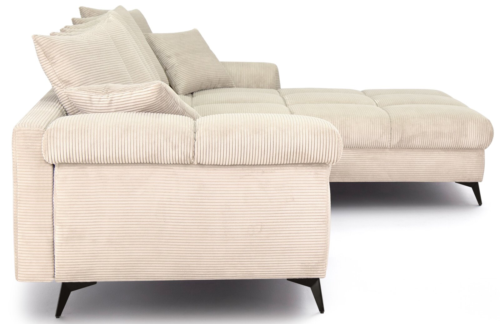 Beiges Cord-Ecksofa mit rechter Ottomane/Recamiere, gepolsterter Sitzfläche und losen Rückenkissen, auf schwarzen Metallfüßen, aus seitlicher Perspektive freigestellt auf weißem Hintergrund