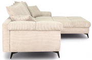 Beiges Cord-Ecksofa mit rechter Ottomane/Recamiere, gepolsterter Sitzfläche und losen Rückenkissen, auf schwarzen Metallfüßen, aus seitlicher Perspektive freigestellt auf weißem Hintergrund