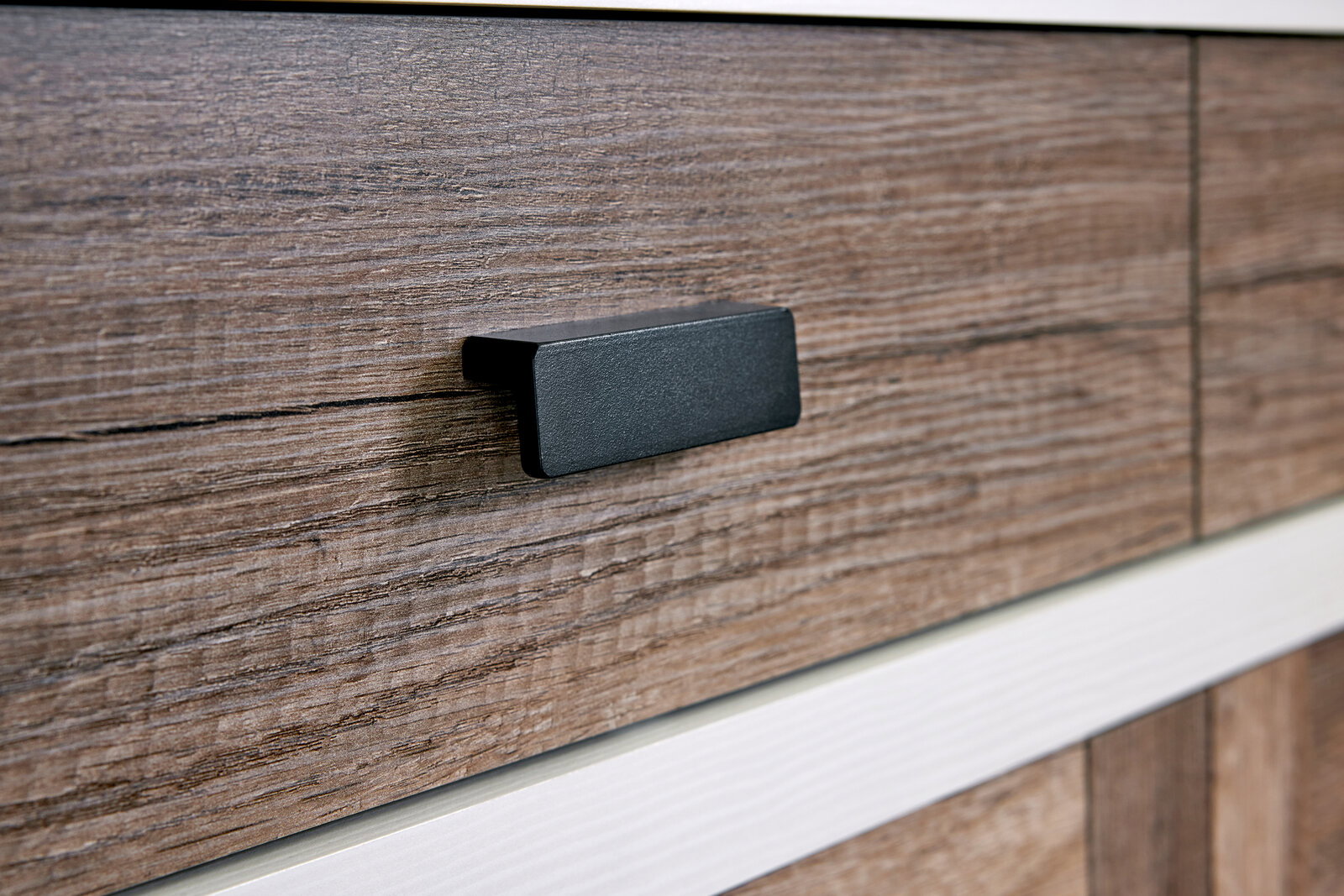 Nahaufnahme eines Sideboards mit Holzmaserung und schwarzem Griff, seitliche Perspektive