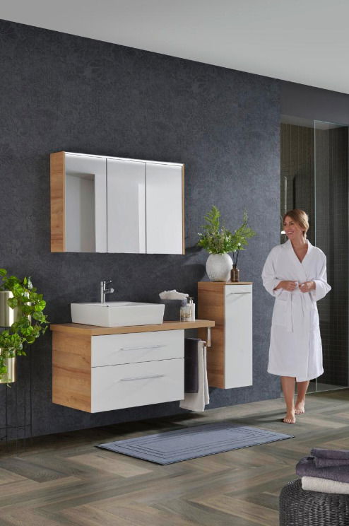 Moderne Badkombination mit Holz- und Weißtönen, bestehend aus einem Waschtisch mit Spiegel und Schrank, seitliche Perspektive.