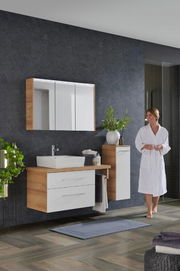 Moderne Badkombination mit Holz- und Weißtönen, bestehend aus einem Waschtisch mit Spiegel und Schrank, seitliche Perspektive.