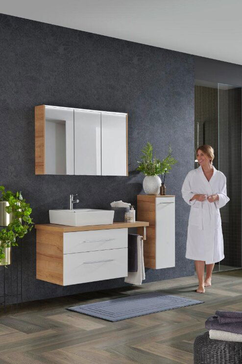 Moderne Badkombination mit Holz- und Weißtönen, bestehend aus einem Waschtisch mit Spiegel und Schrank, seitliche Perspektive.