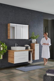 Moderne Badkombination mit Holz- und Weißtönen, bestehend aus einem Waschtisch mit Spiegel und Schrank, seitliche Perspektive.