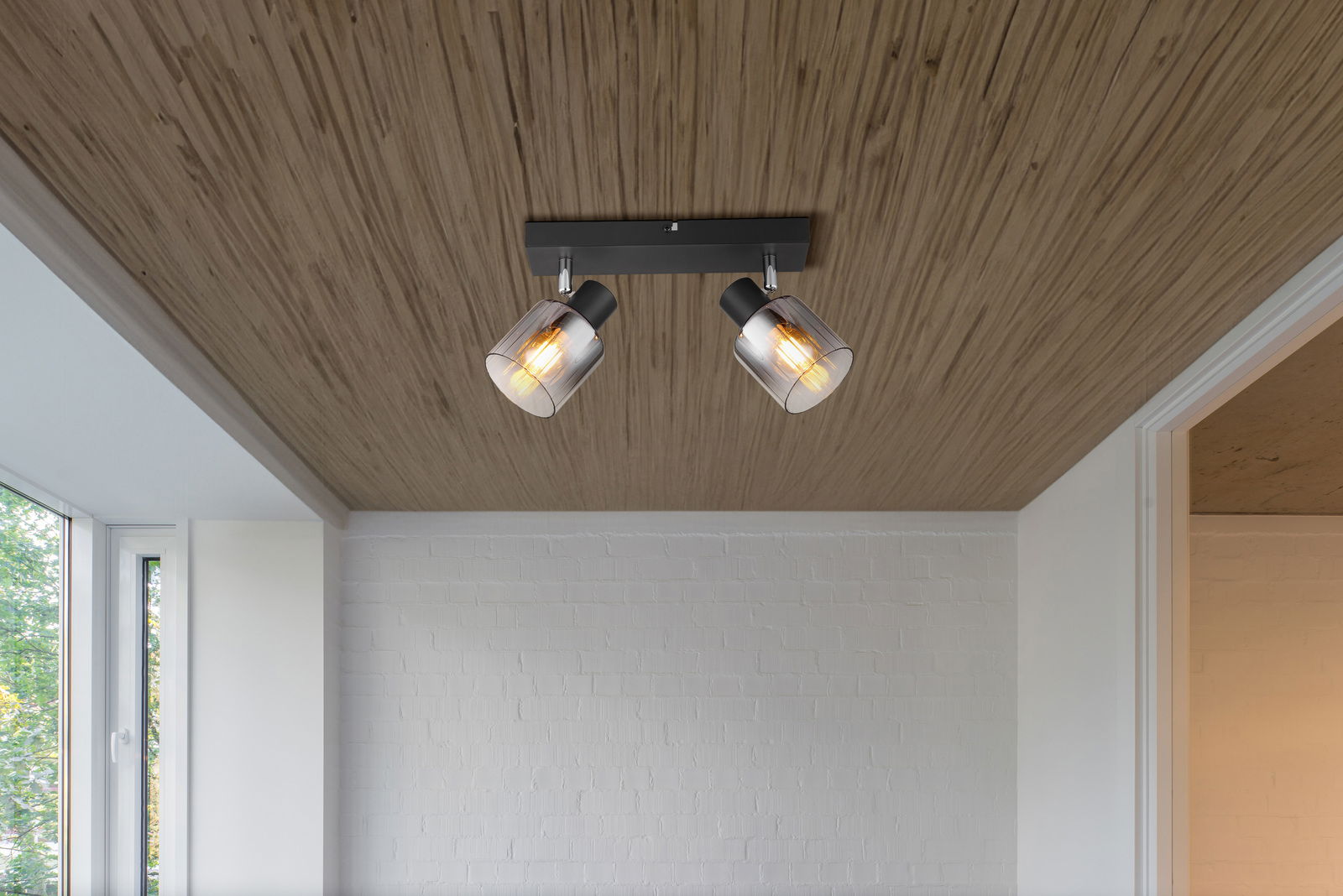 Deckenstrahler mit zwei verstellbaren Leuchten, montiert an einer Holzdecke, seitliche Perspektive.