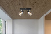 Deckenstrahler mit zwei verstellbaren Leuchten, montiert an einer Holzdecke, seitliche Perspektive.