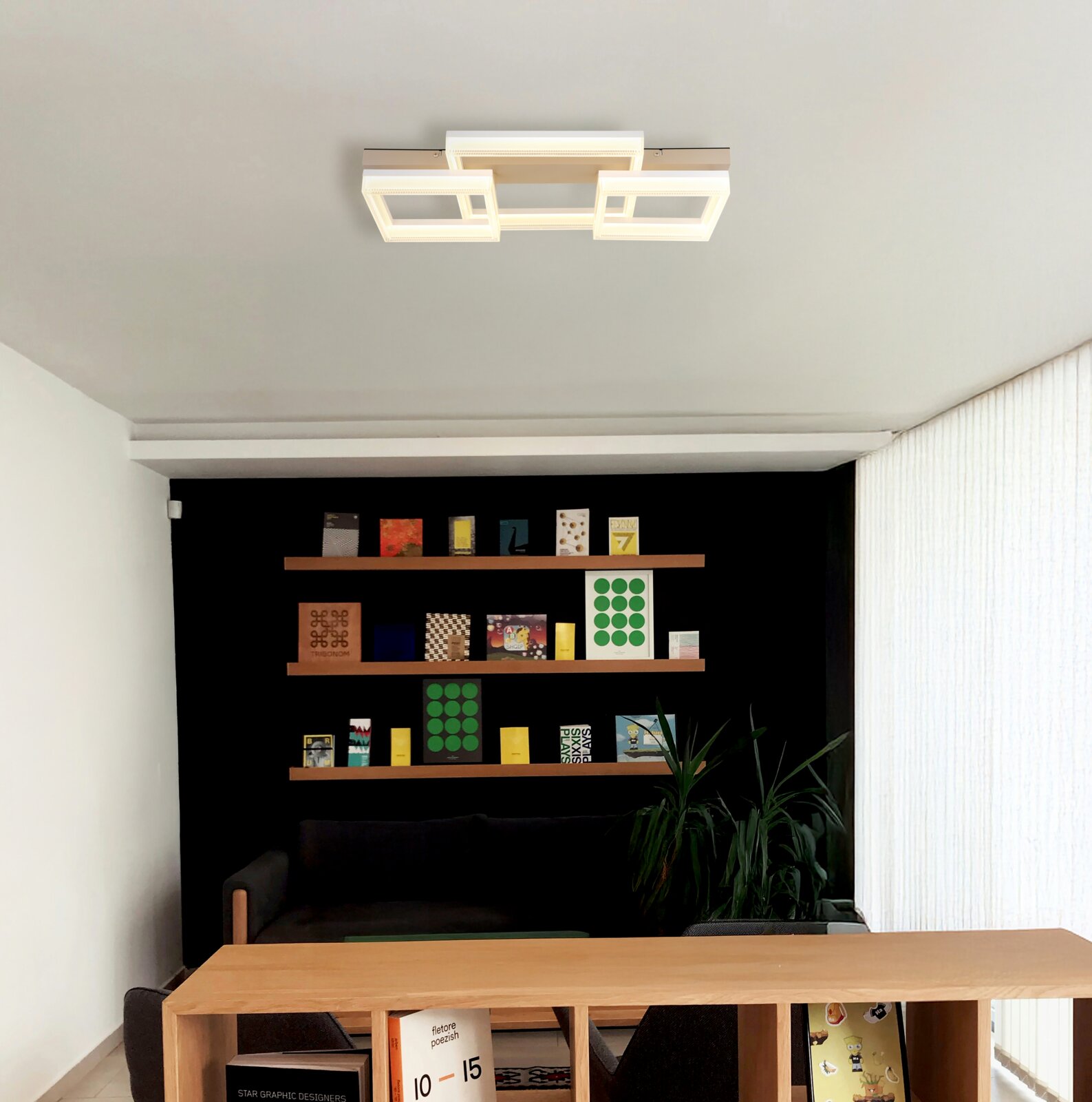 Moderne led-plafondlamp met een geometrisch ontwerp, gezien van onderaf in een stijlvolle woonkamer met boekenkast.