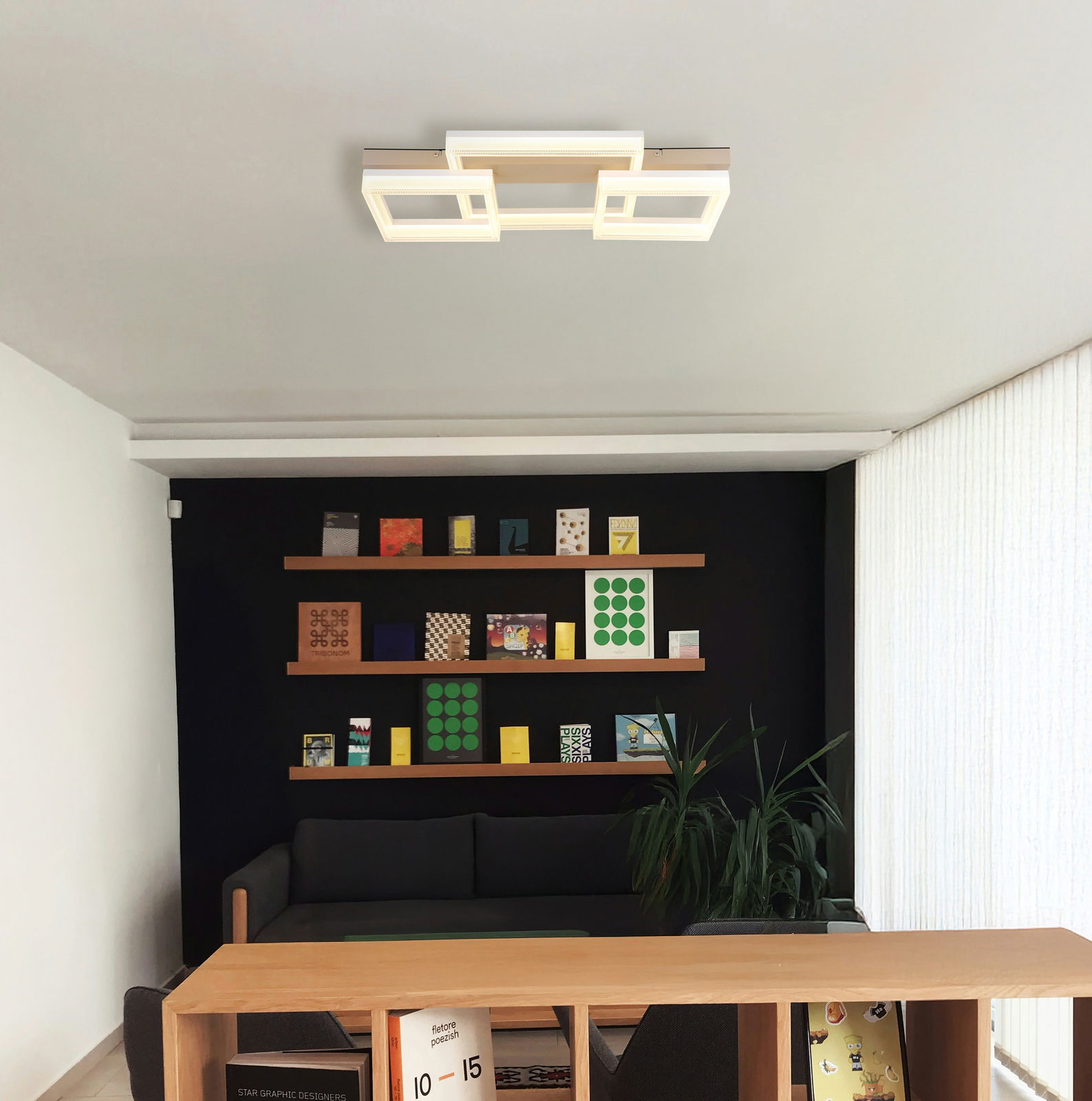 Moderne LED-Deckenleuchte in geometrischem Design, von unten betrachtet in einem stilvollen Wohnzimmer mit Bücherregal.