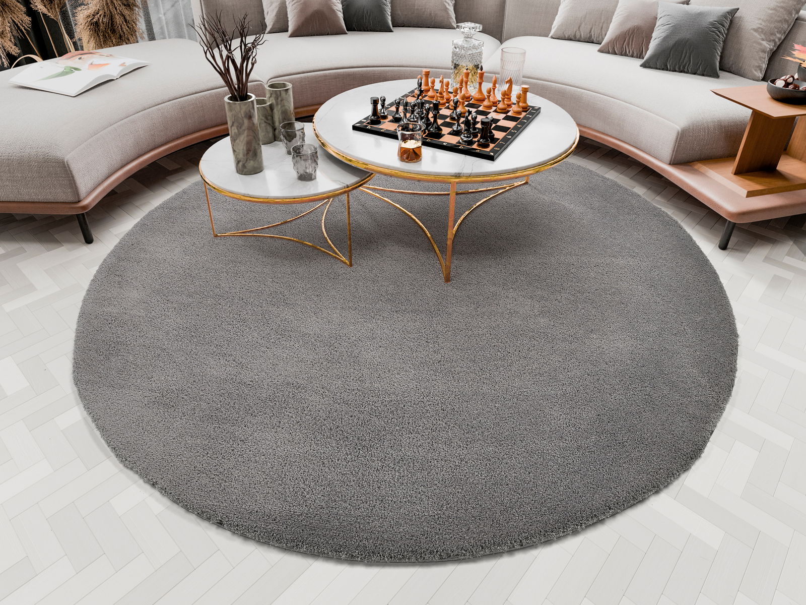 Runder grauer Teppich Soft Dream, ca. 120 cm, in einem modernen Wohnzimmer mit einem eleganten Couchtisch und einem Schachspiel, von oben betrachtet.
